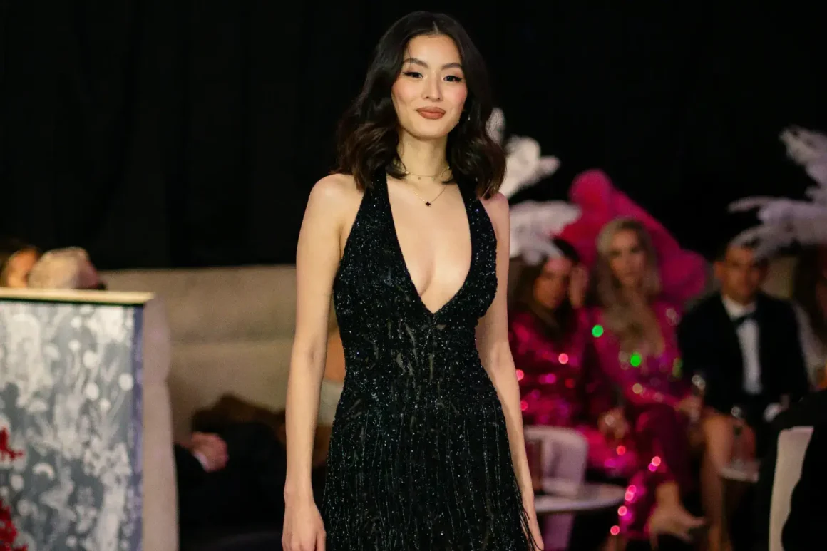Femme asiatique qui défile dans une tenue de soirée noir sexy avec un décolté