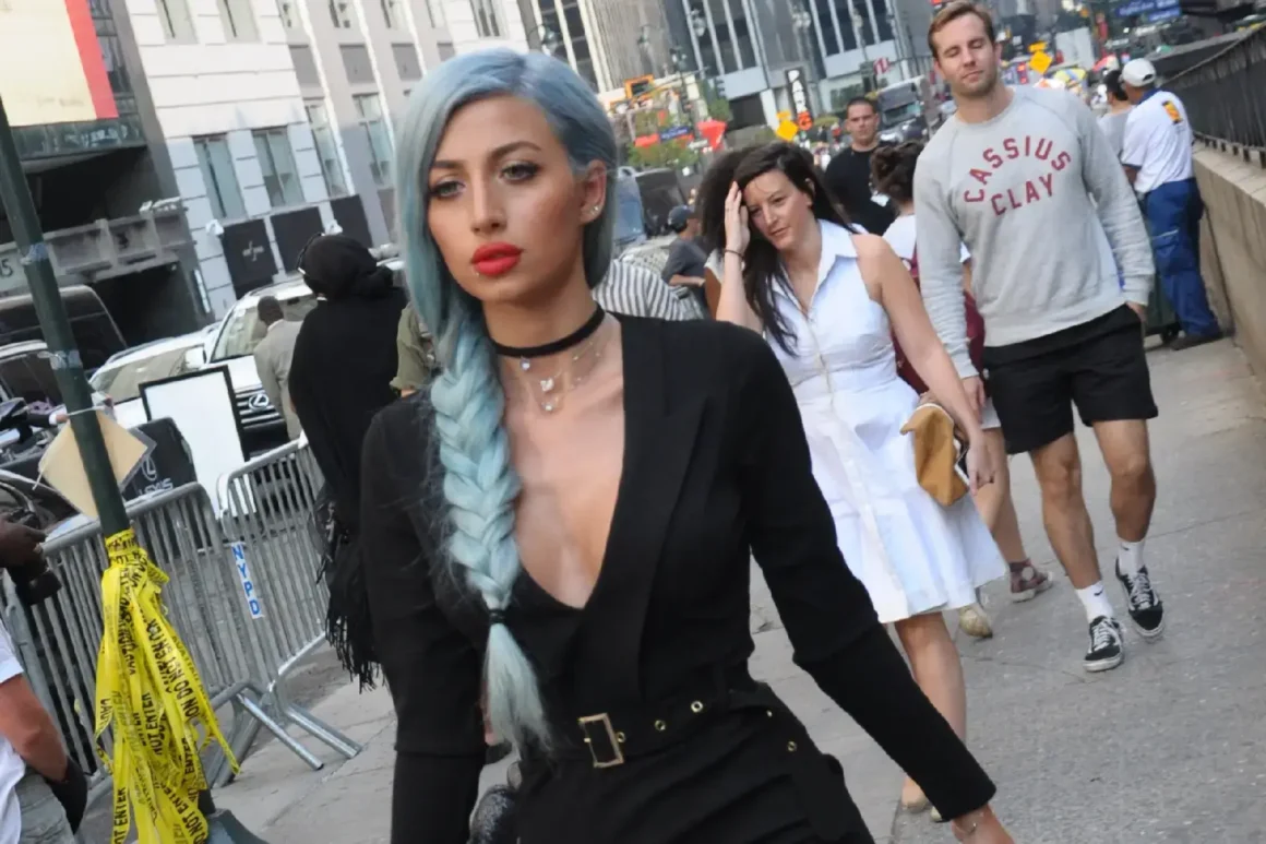 Femme new-yorkaise aux cheveux coloré bleu dans une tenue noir sexy