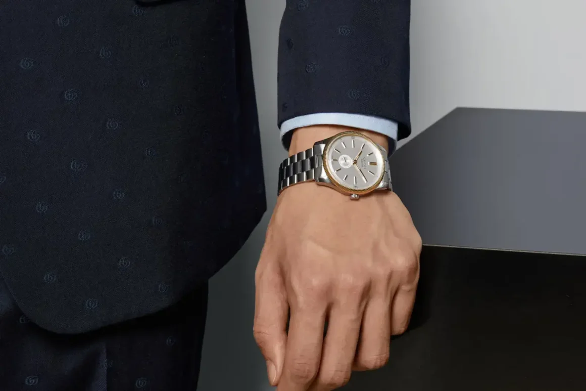 Le G-Timeless - main homme en costume bleu qui porte une montre Le G-Timeless.avif