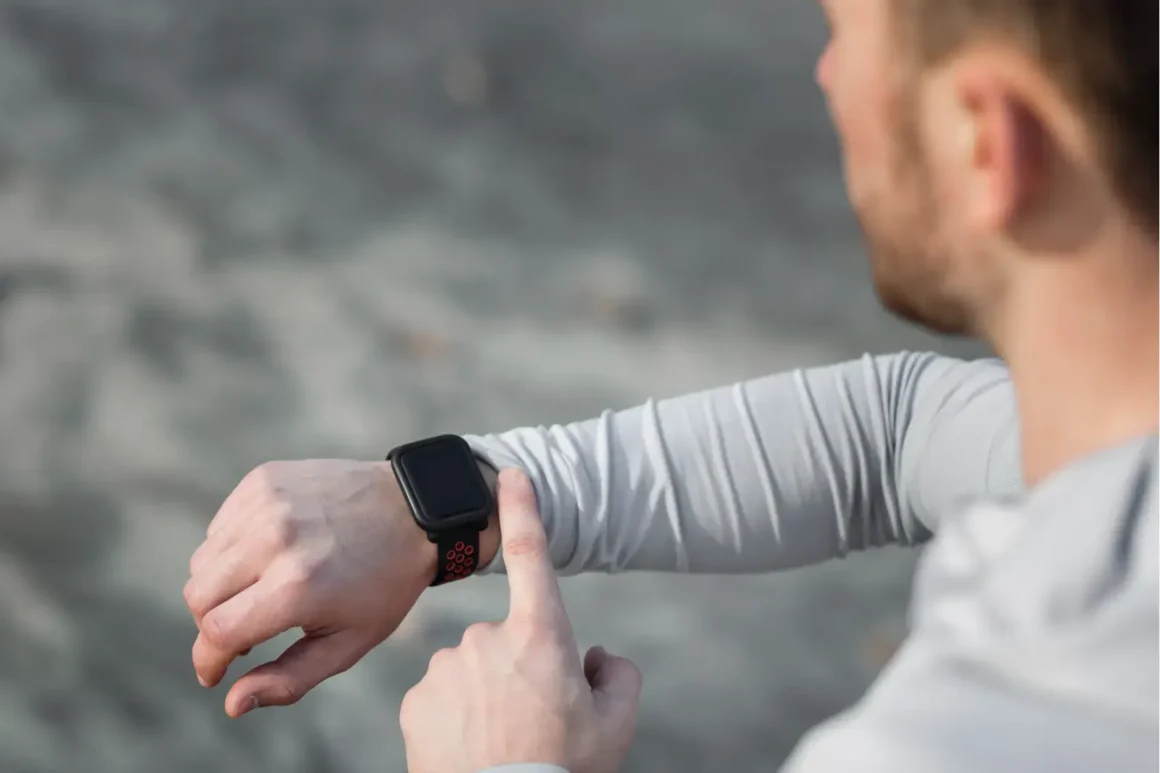 vue-arriere-homme-ajustant-sa-montre-de-sport